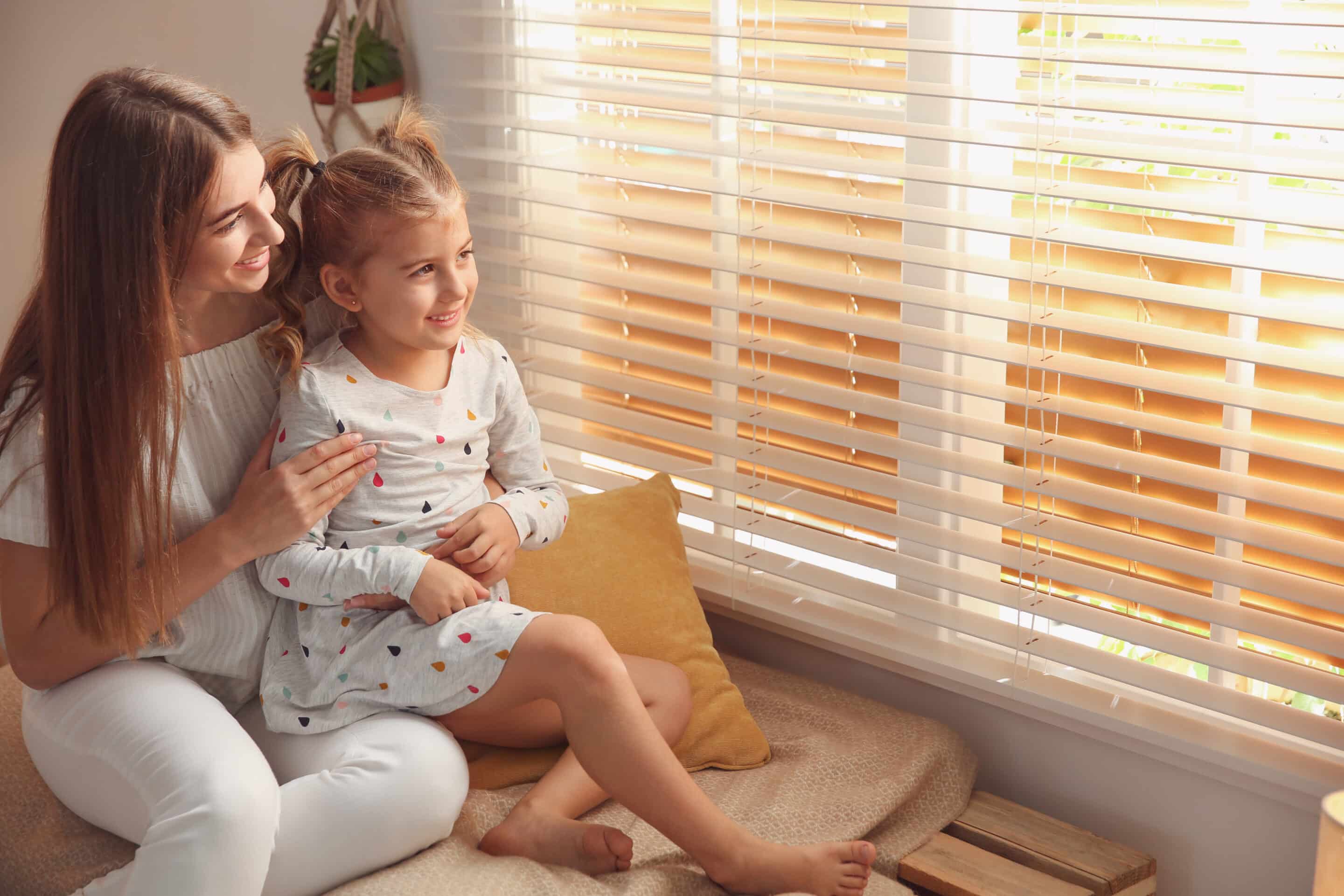 Blinds North Carolina, mom and daughter looking out the window in bedroom