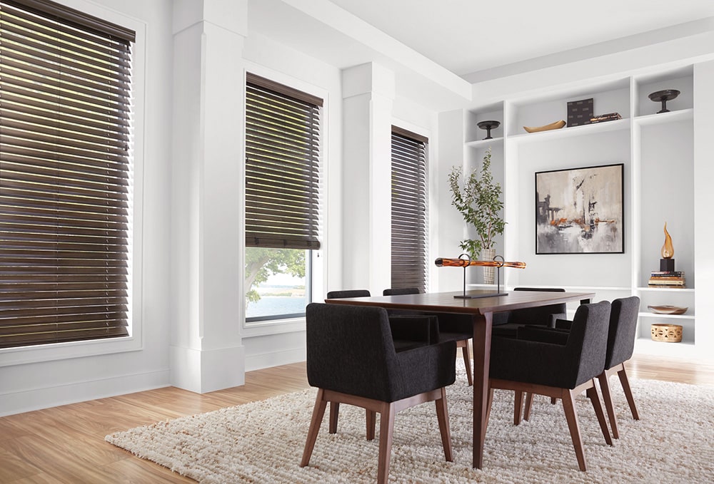 Faux wood blinds letting in natural light into a dining room.