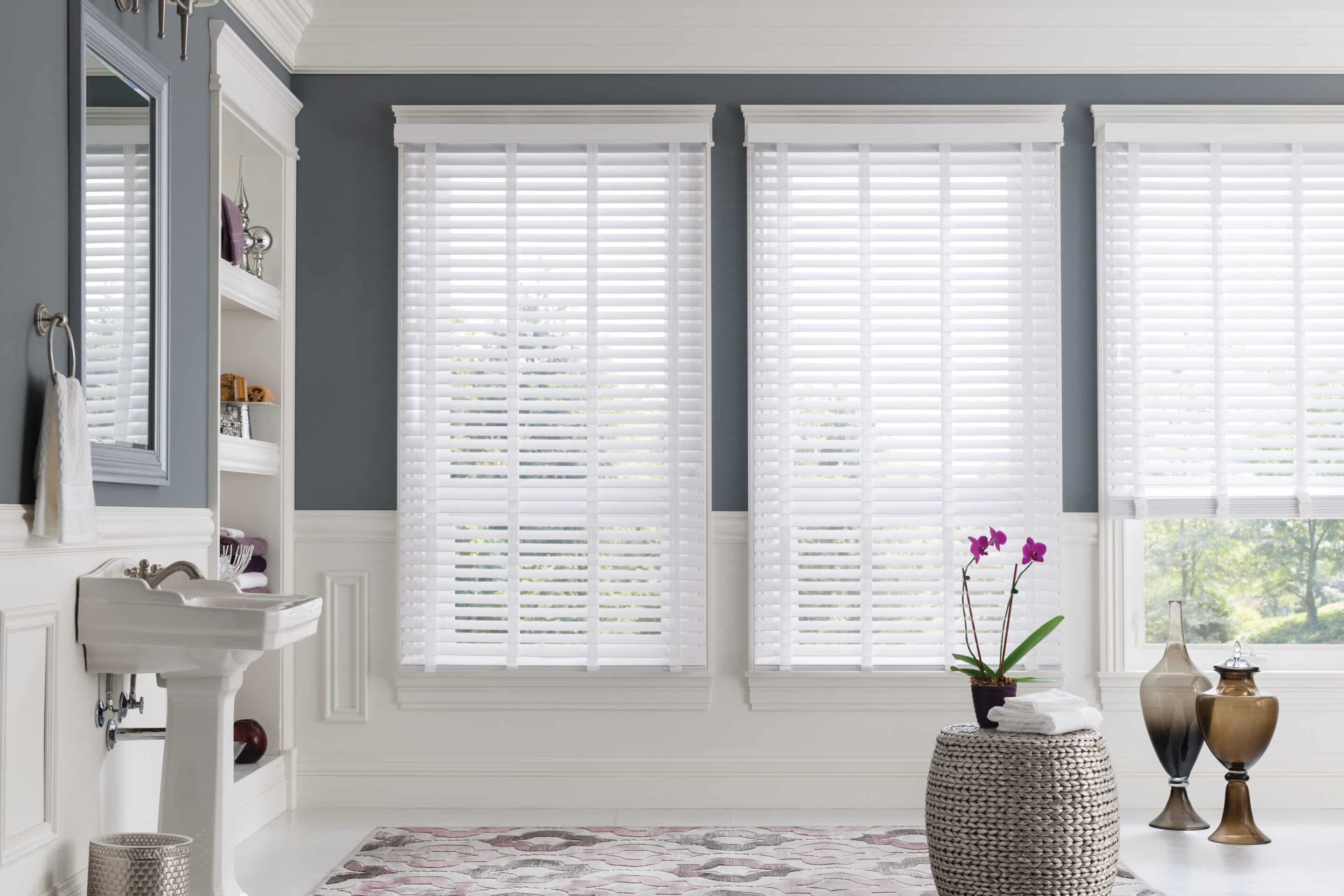 Faux wood blinds filtering in light into a well decorated bathroom.